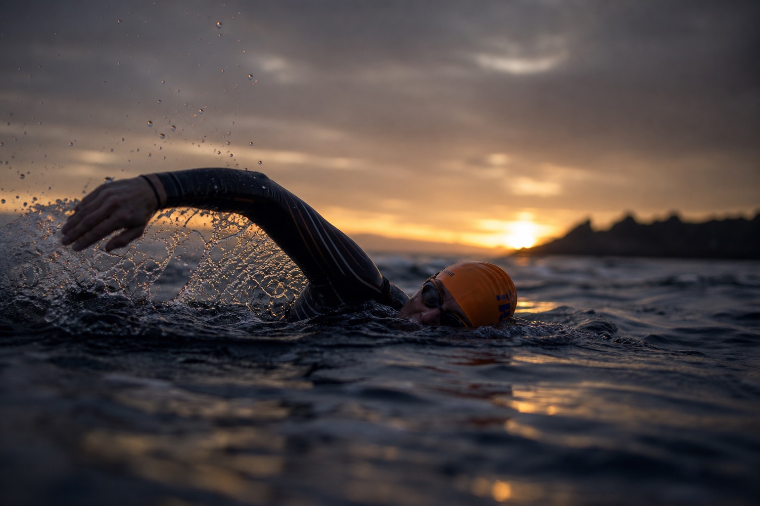Open-water swimmer at sunrise